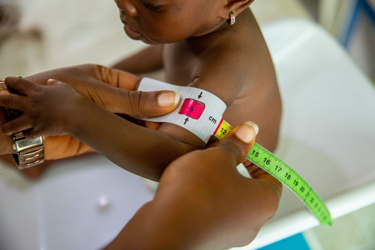 A measuring tape being used to measure a child
