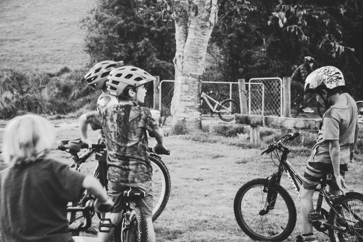 Children with helmets standing with their bikes