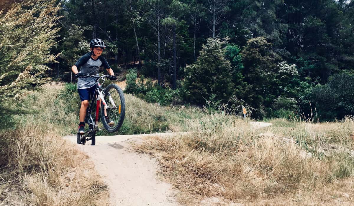 A child riding a bike on a dirt trail