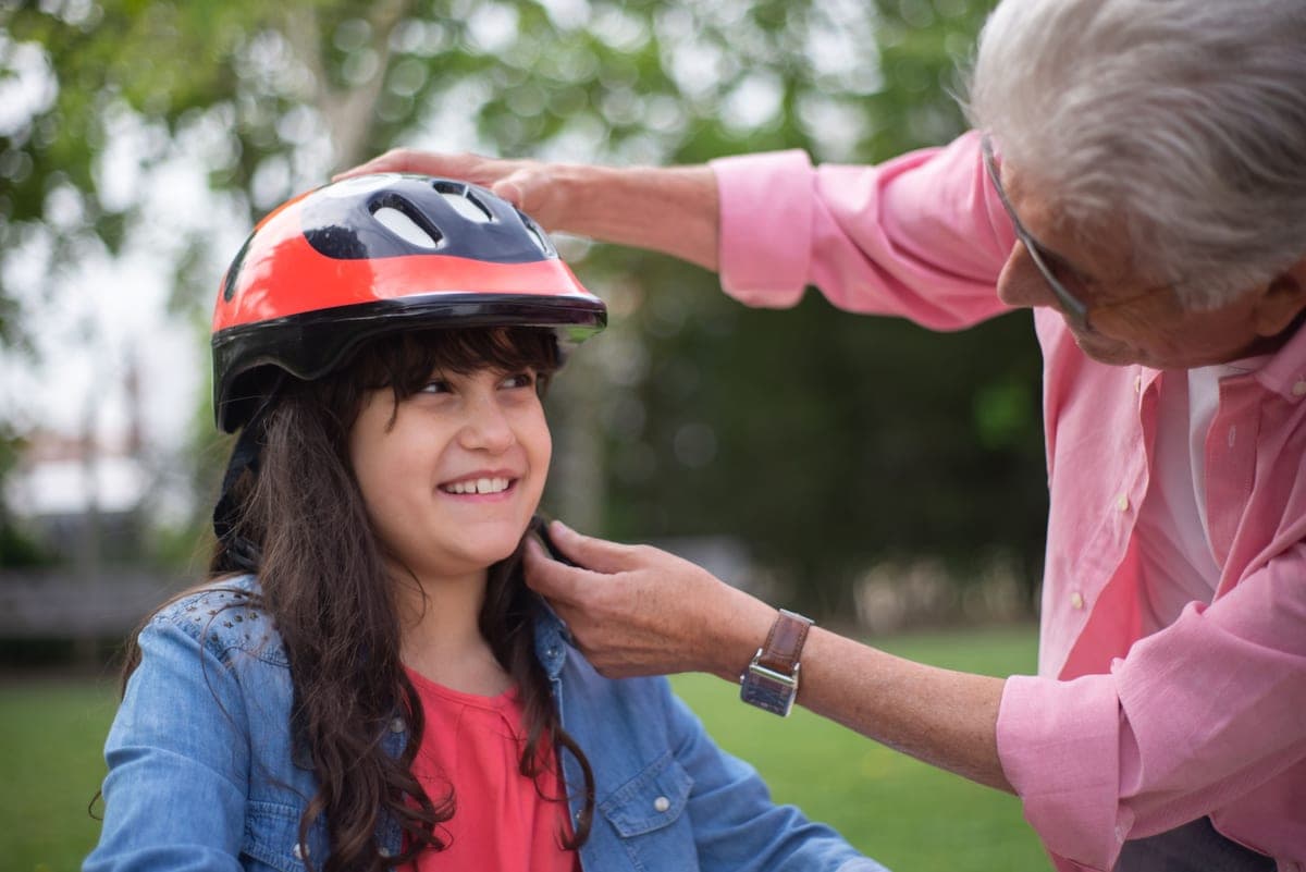 A small child wearing a helmet on a balance bike